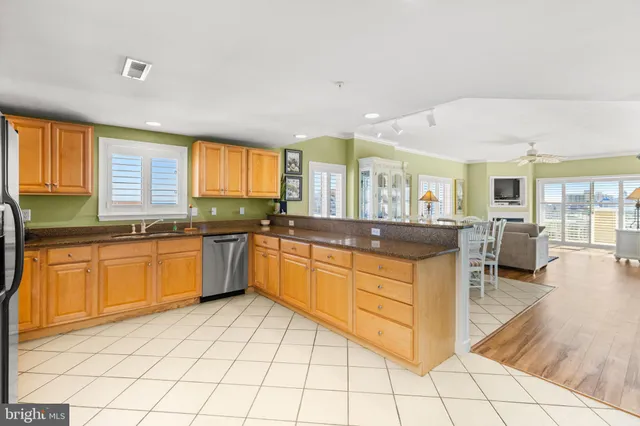 a large kitchen with granite countertop a large counter top space a sink a window and stainless steel appliances