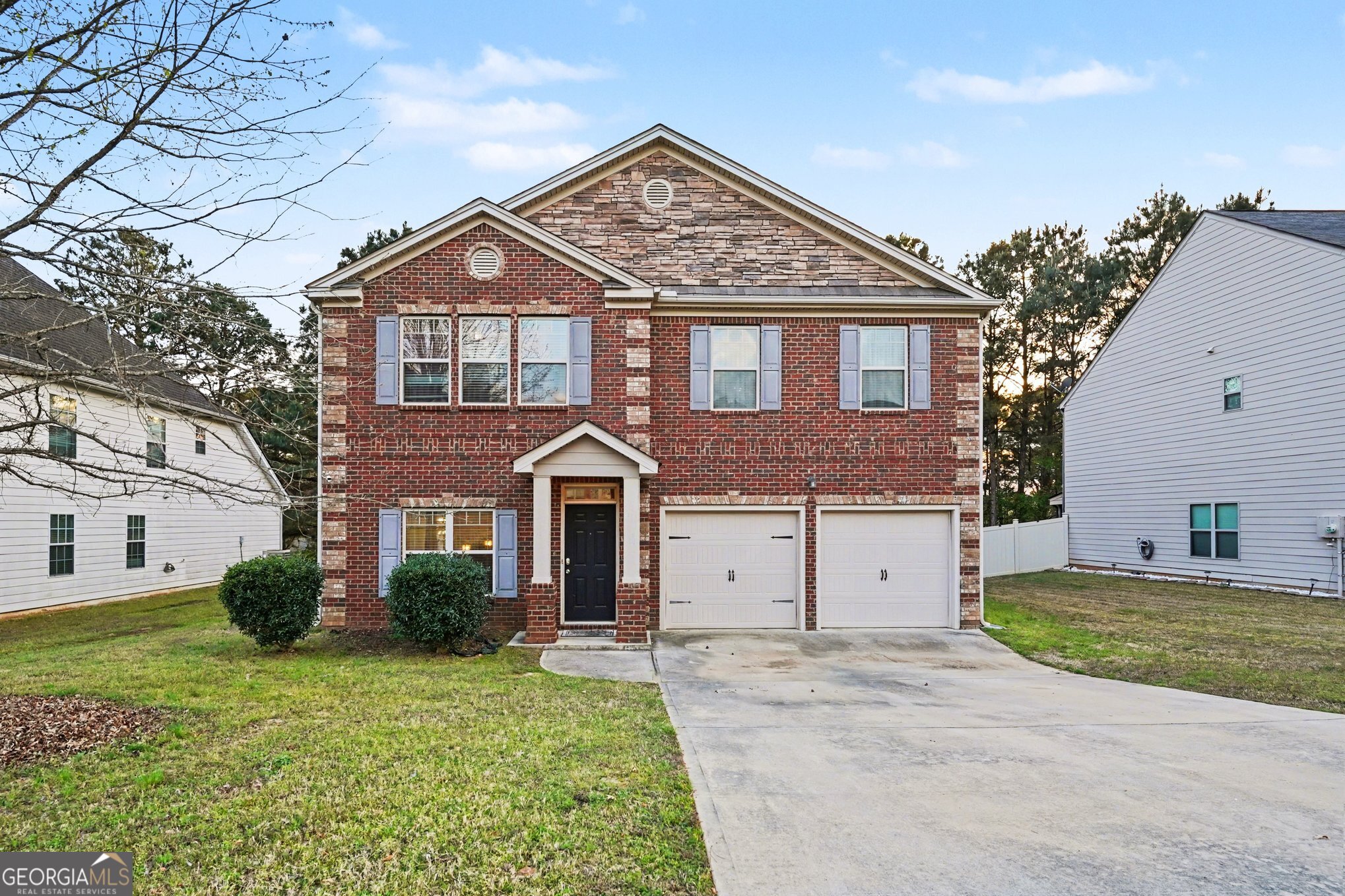 a front view of a house with a garden and plants