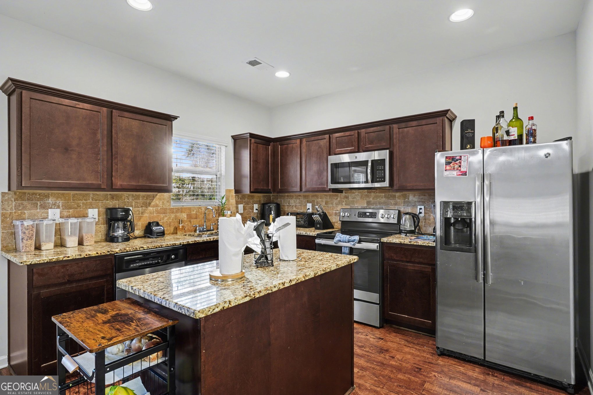 1241 England Terrace Hampton, GA 30228 - Photo 7 of 20 a kitchen with granite countertop stainless steel appliances and wooden cabinets