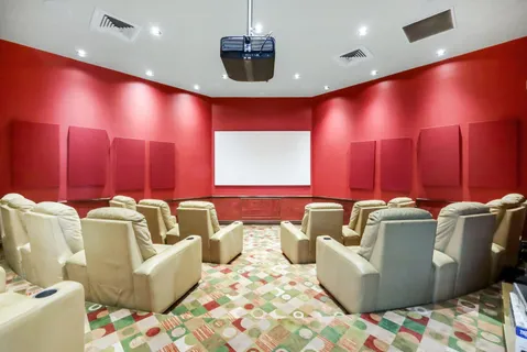 a living room with furniture and a projector screen