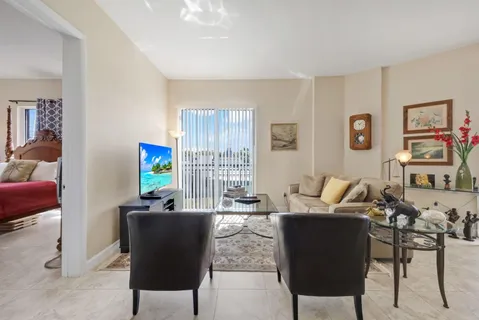 a living room with furniture a computer on the desk and a window