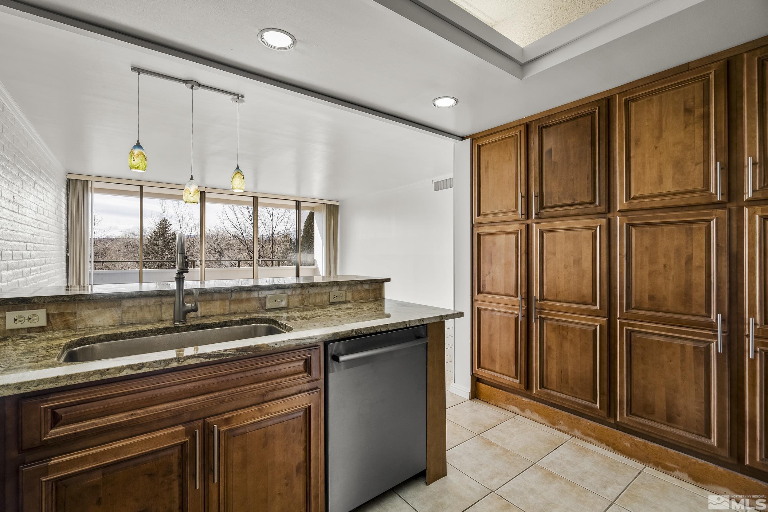 1200 Riverside Drive, Unit #1209 Reno, NV 89503 - Photo 15 of 35 a kitchen with stainless steel appliances granite countertop a refrigerator and a sink
