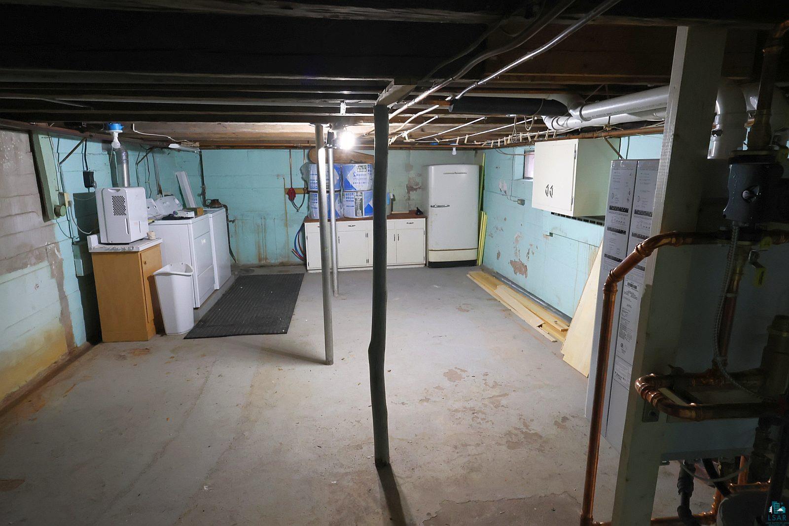 83185 Washington Avenue Port Wing, WI 54865 - Photo 20 of 26 Unfinished basement featuring exposed ceiling joists, concrete flooring, and a utility area with cabinetry