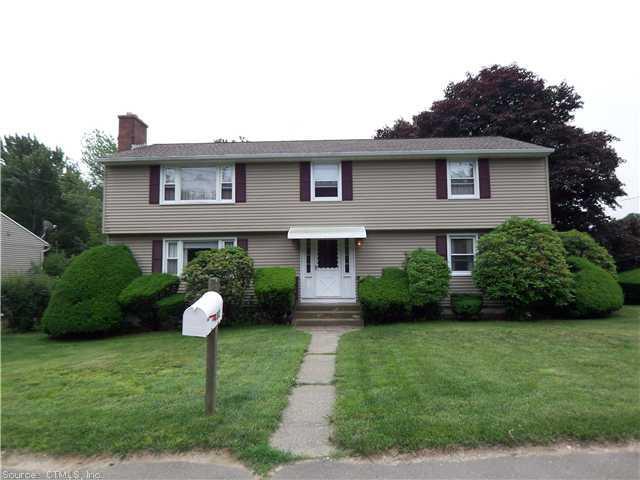 a front view of a house with a garden and plants