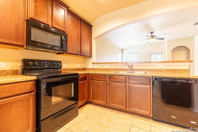 a kitchen with stainless steel appliances granite countertop a stove microwave and sink