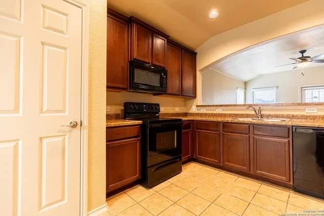 a kitchen with stainless steel appliances granite countertop a refrigerator and a stove top oven