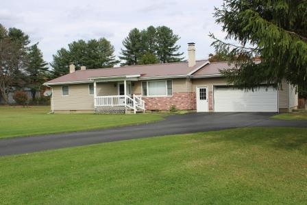 16544 Tionesta Road Pleasantville, PA 16341 - Photo 1 of 32 a front view of a house with a garden and plants