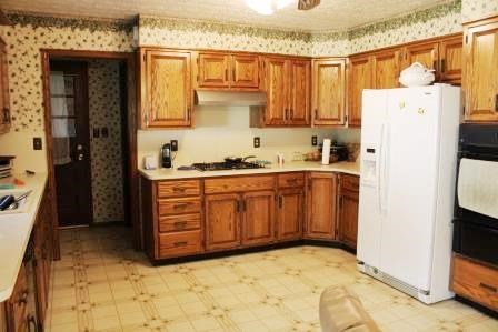 16544 Tionesta Road Pleasantville, PA 16341 - Photo 21 of 32 a kitchen with a refrigerator a stove a sink dishwasher and wooden cabinets