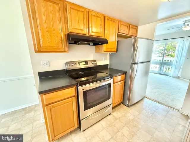 a kitchen with stainless steel appliances granite countertop a refrigerator a stove a sink and a cabinets