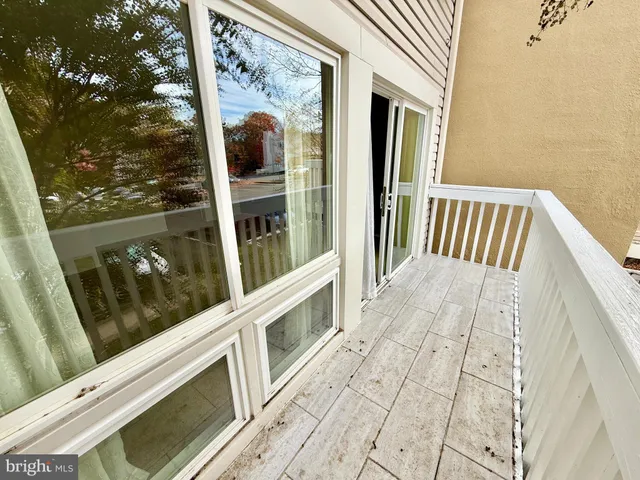 a view of a balcony with wooden floor and iron fence