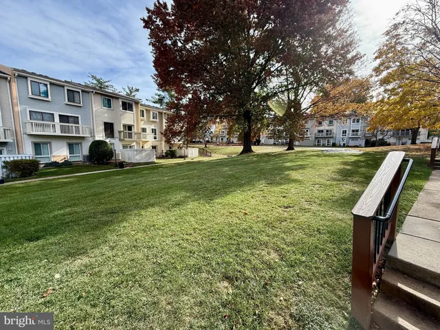 a view of a big yard with a house and large trees