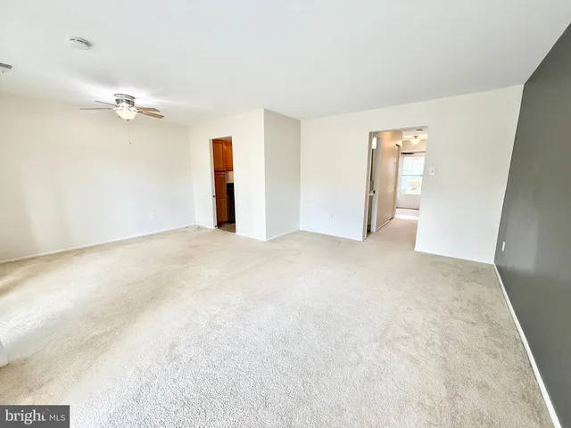 an empty room with a ceiling fan and a window