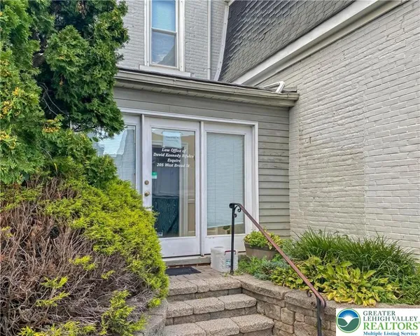 a front view of a house with plants