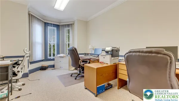 a view of a workspace with furniture and a window