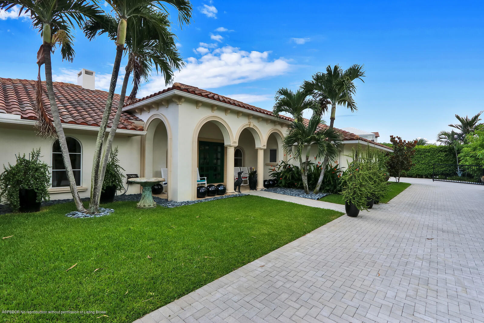 95 Spoonbill Road Manalapan, FL 33462 - Photo 2 of 32 a front view of a house with a garden and trees