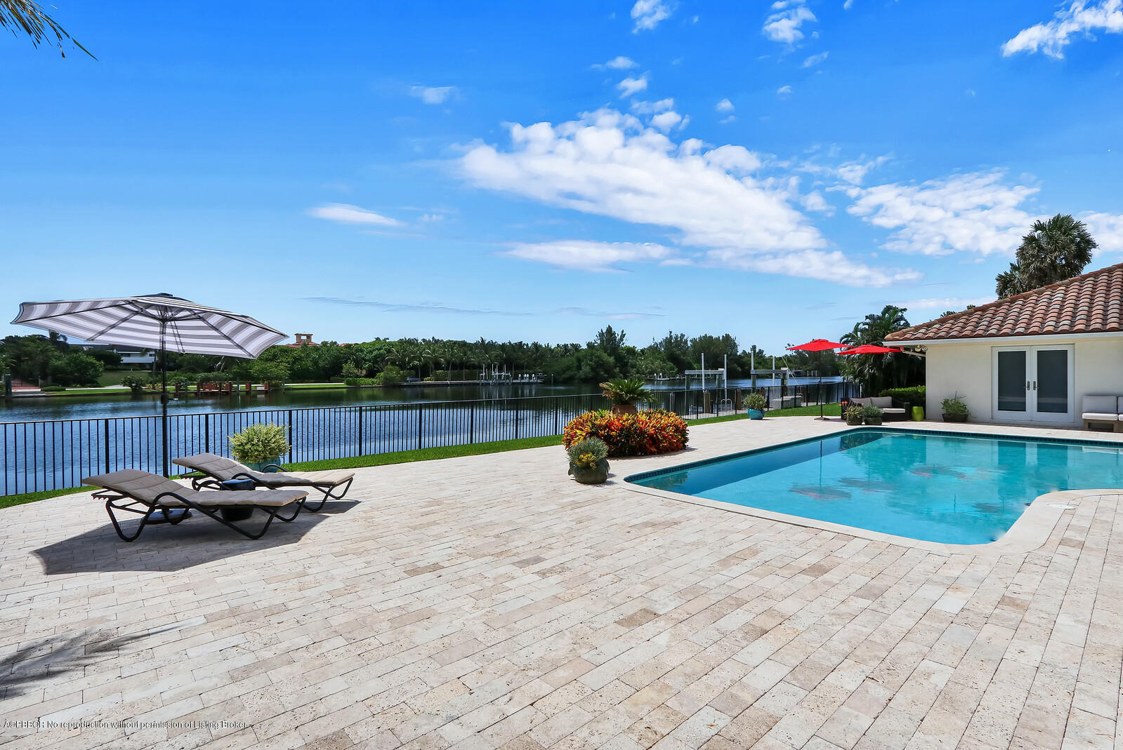 95 Spoonbill Road Manalapan, FL 33462 - Photo 25 of 32 a view of a swimming pool with a lounge chairs and a table