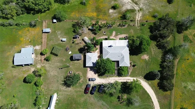 an aerial view of a house with a yard lake house swimming pool and outdoor seating