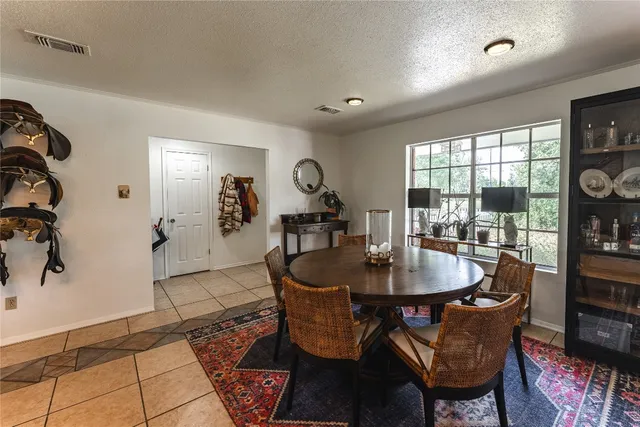 a dining room with furniture and large windows