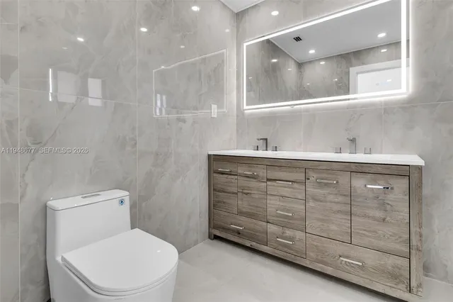 a bathroom with a toilet a sink a mirror and a shower