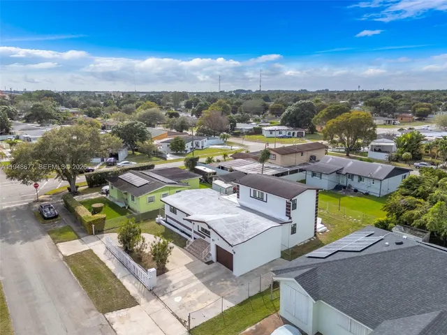 an aerial view of a house with swimming pool and ocean view