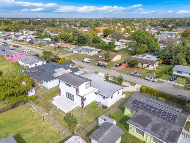 an aerial view of residential houses with outdoor space and ocean view