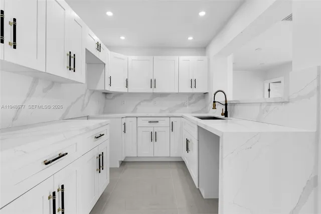 a kitchen with white cabinets appliances and a sink