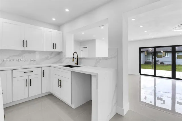 a kitchen with granite countertop white cabinets and white appliances