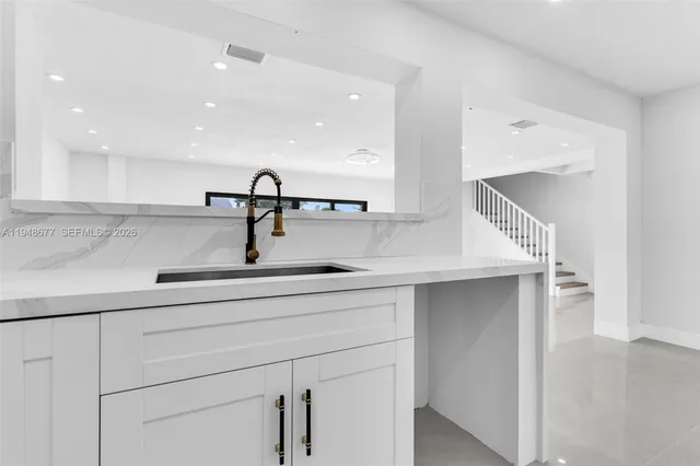 a kitchen with a sink and white cabinets