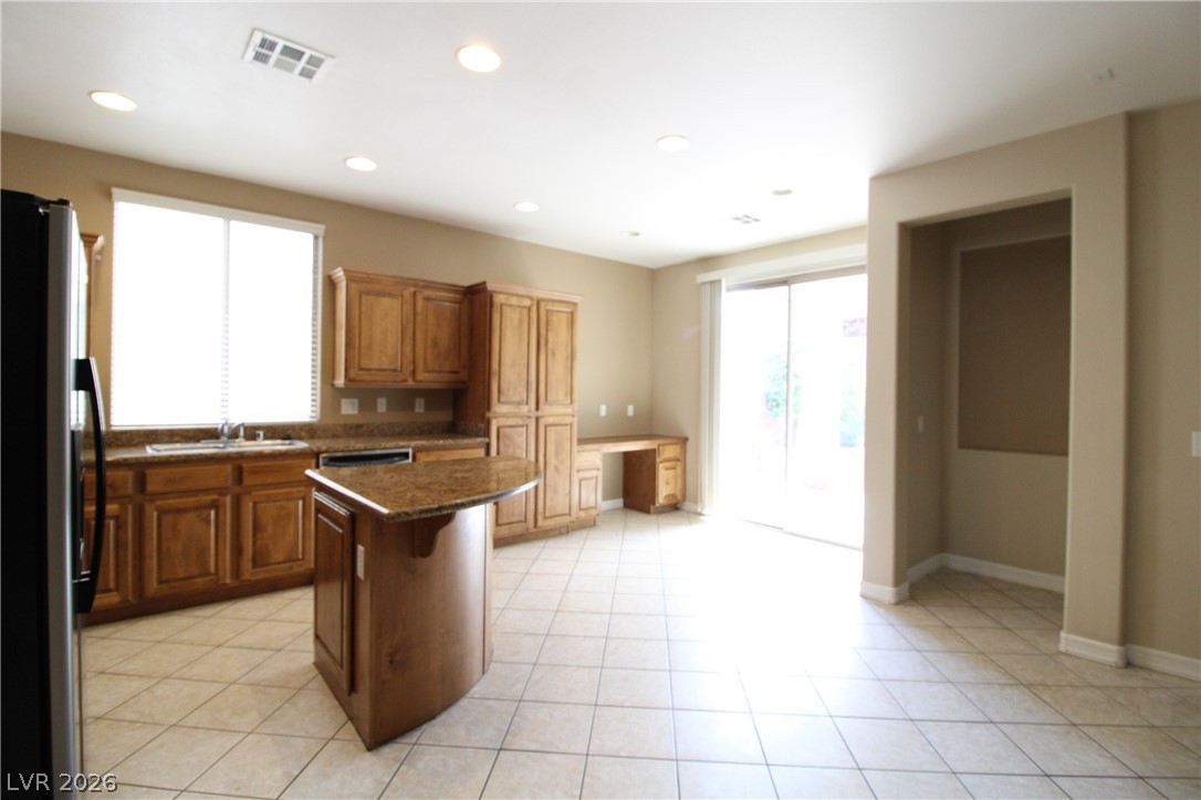 754 Rise Canyon Drive Henderson, NV 89052 - Photo 19 of 34 A well-lit kitchen with granite countertops and a central island awaits your culinary adventures.