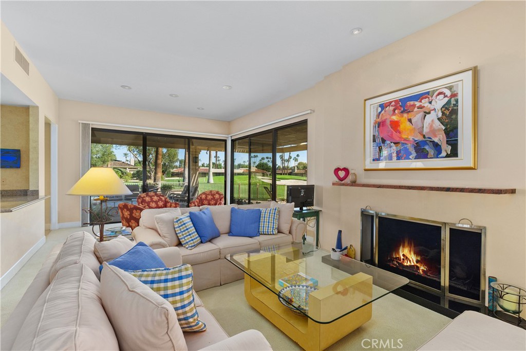 a living room with furniture a fireplace and a large window