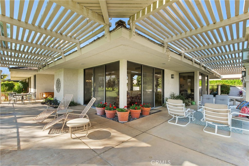 5 Princeton Drive Rancho Mirage, CA 92270 - Photo 2 of 27 a view of a patio with table and chairs and floor to ceiling window