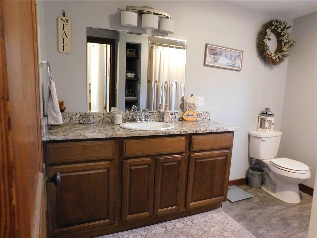 235 Ridge Road Brownsville, PA 15417 - Photo 17 of 42 a bathroom with a granite countertop sink a toilet and mirror