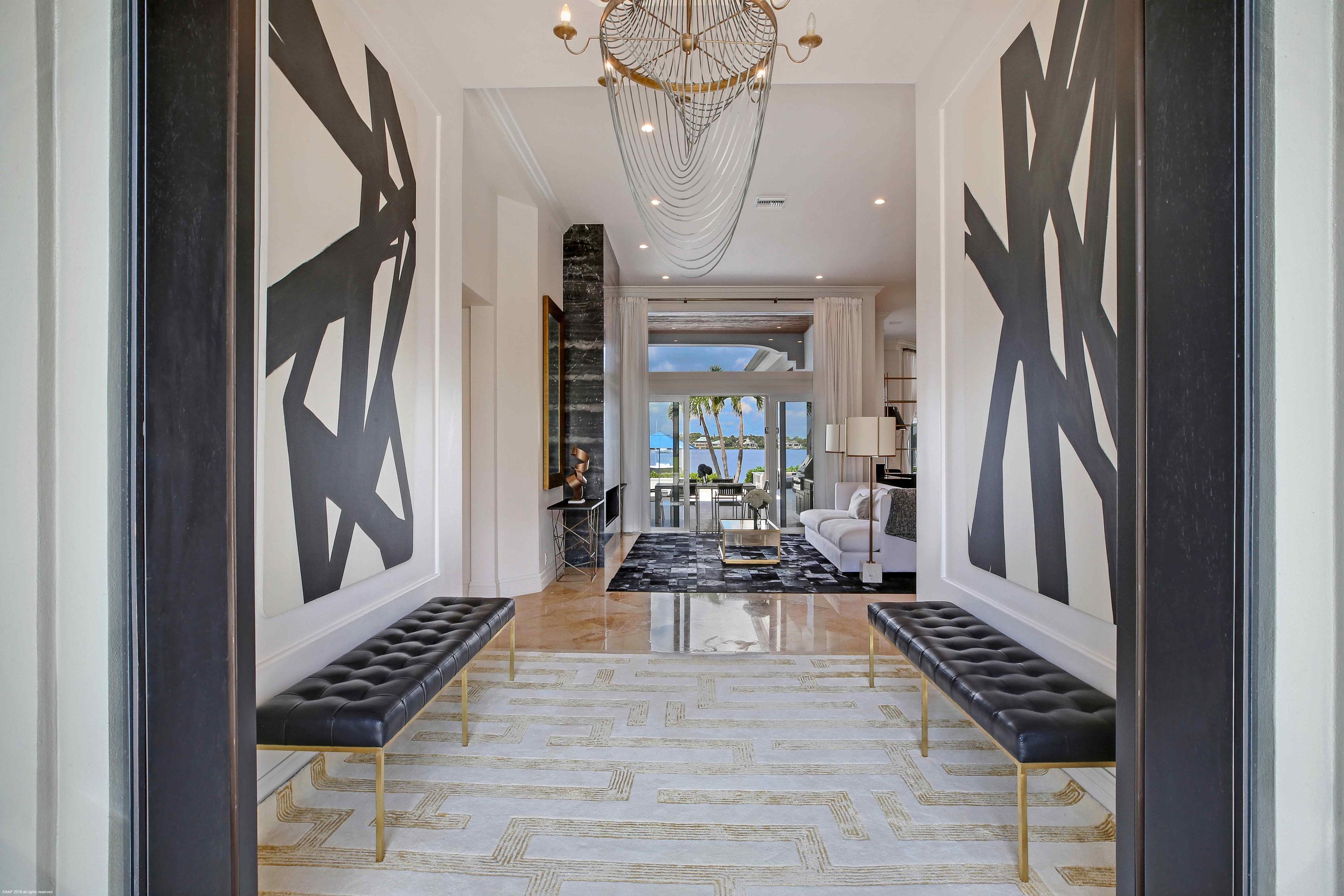 263 River Drive Tequesta, FL 33469 - Photo 12 of 68 a view of a hallway to a livingroom with wooden floor and furniture