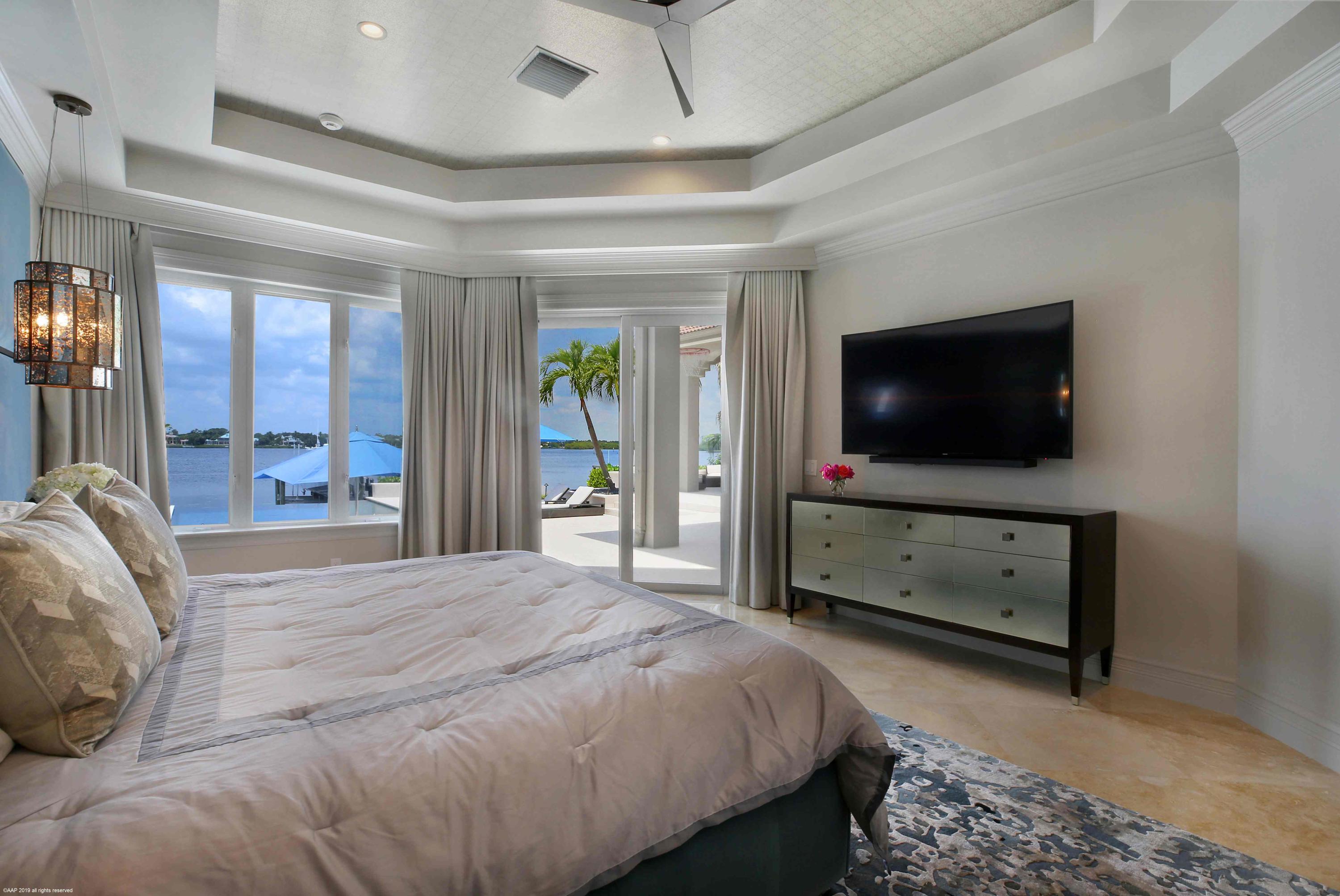 263 River Drive Tequesta, FL 33469 - Photo 35 of 68 a bedroom with a bed and a flat screen tv