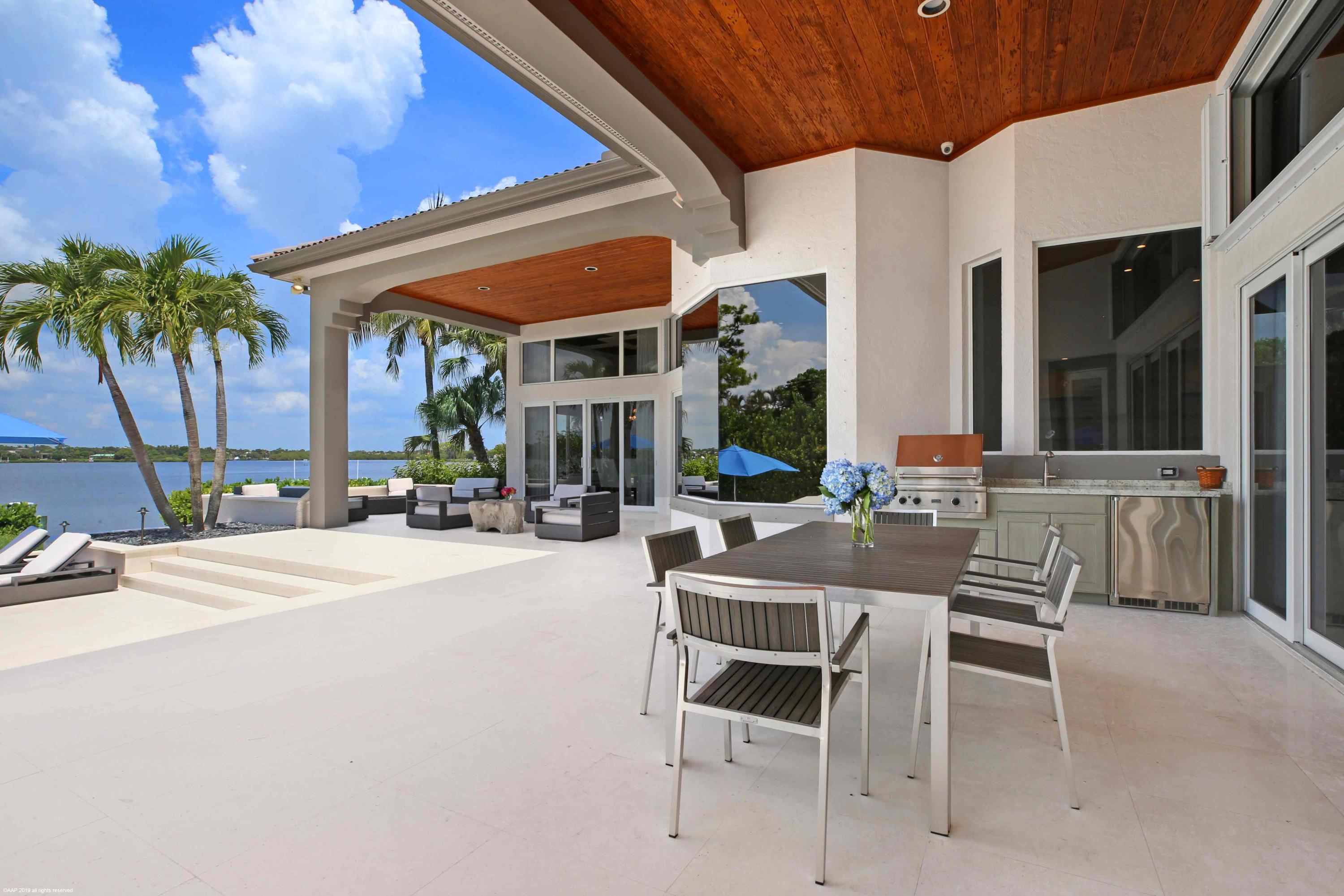 263 River Drive Tequesta, FL 33469 - Photo 53 of 68 a view of a patio with a table and chairs and potted plants