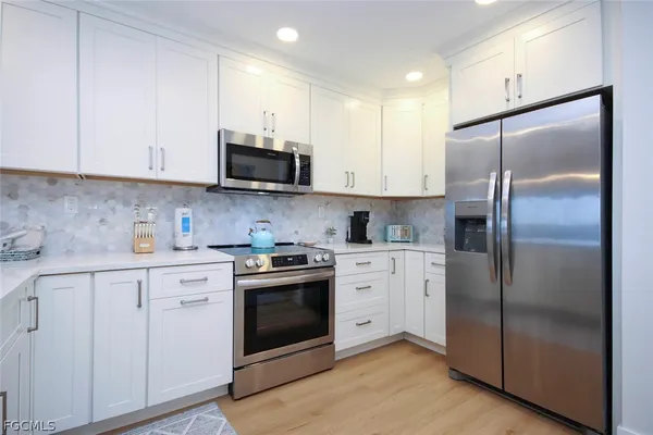 a kitchen with cabinets stainless steel appliances and a counter space