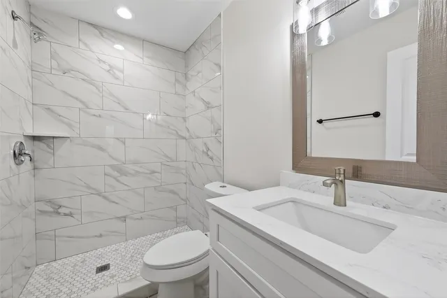 a bathroom with a sink a toilet and shower