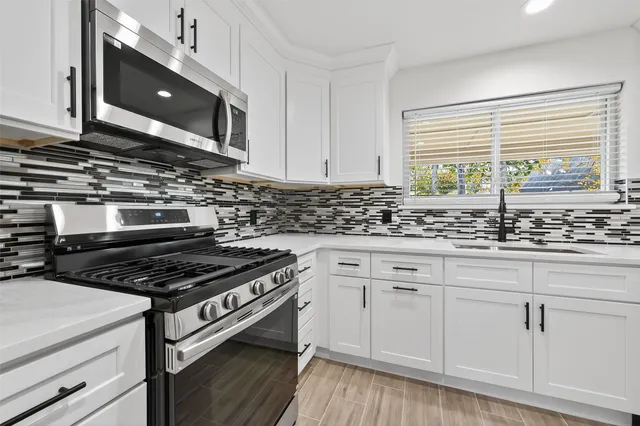 a kitchen with granite countertop a stove and a sink