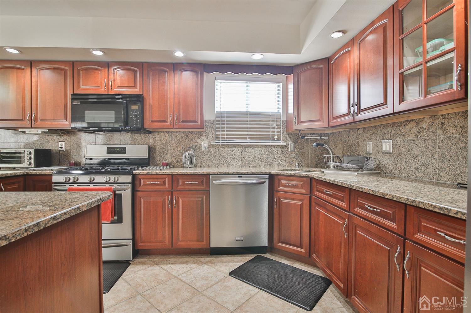 5 Avery Drive Old Bridge, NJ 08857 - Photo 16 of 32 a kitchen with stainless steel appliances granite countertop wooden cabinets a stove top oven a sink and dishwasher