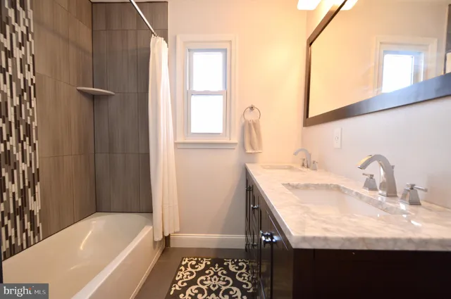 a bathroom with a granite countertop sink and a bathtub