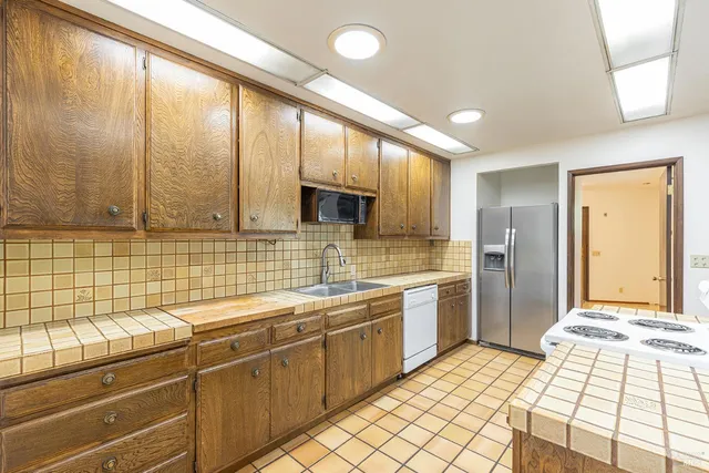 a bathroom with a granite countertop toilet and a sink