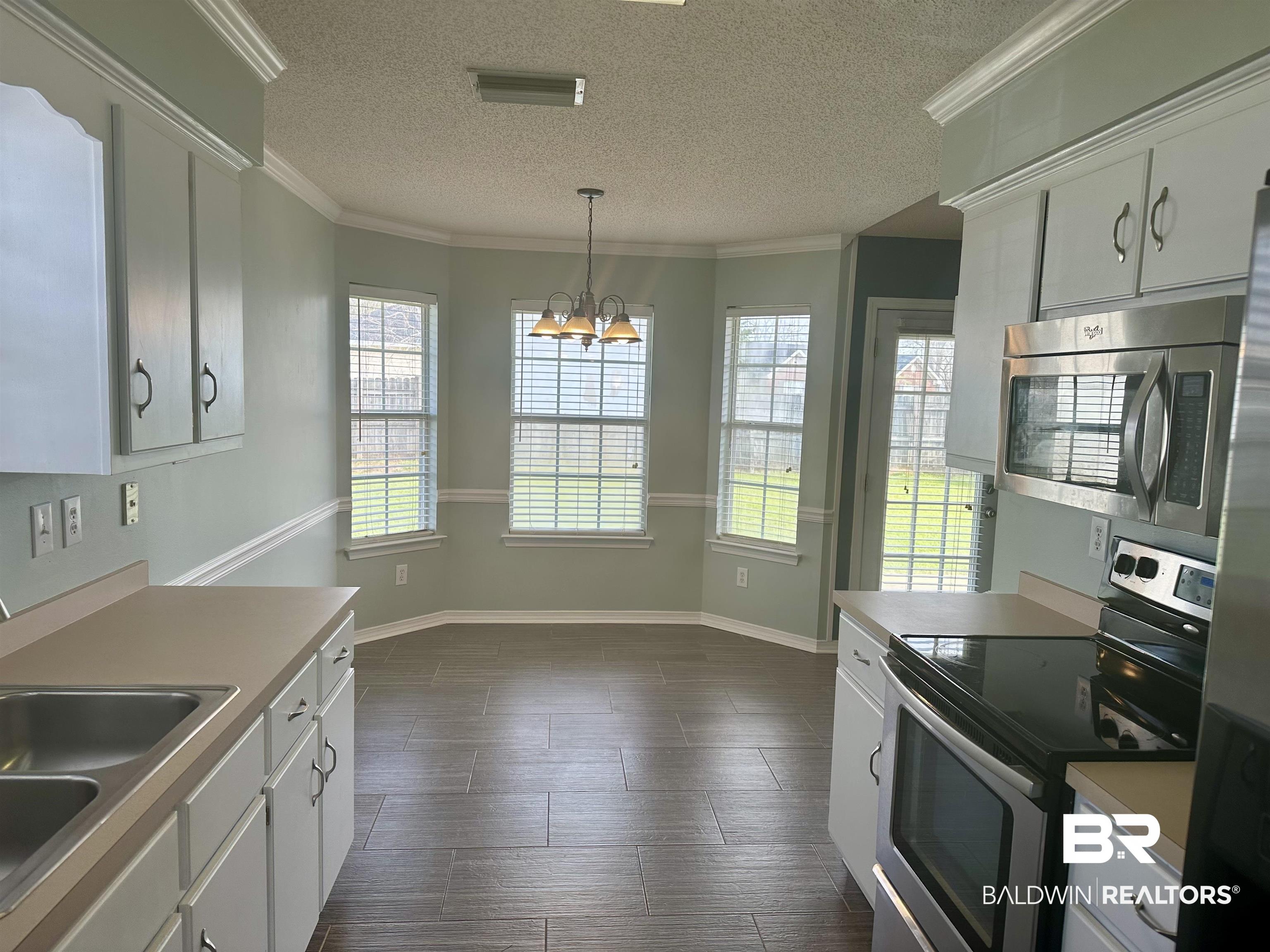 4882 Rebecca Place Mobile, AL 36695 - Photo 27 of 29 Kitchen featuring visible vents, a chandelier, ornamental molding, stainless steel appliances, and a sink