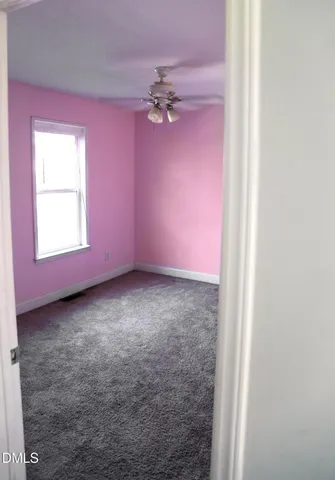 a bathroom with a granite countertop toilet a sink and a window