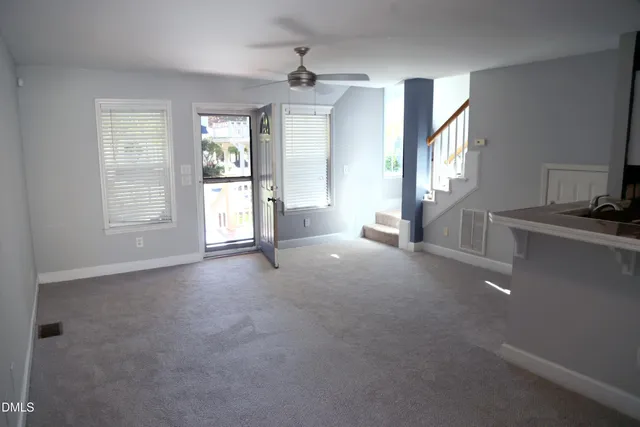 a view of a livingroom with a ceiling fan and window