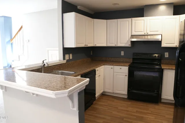 a kitchen with granite countertop a sink and cabinets