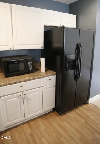 a kitchen with stainless steel appliances white cabinets and a refrigerator