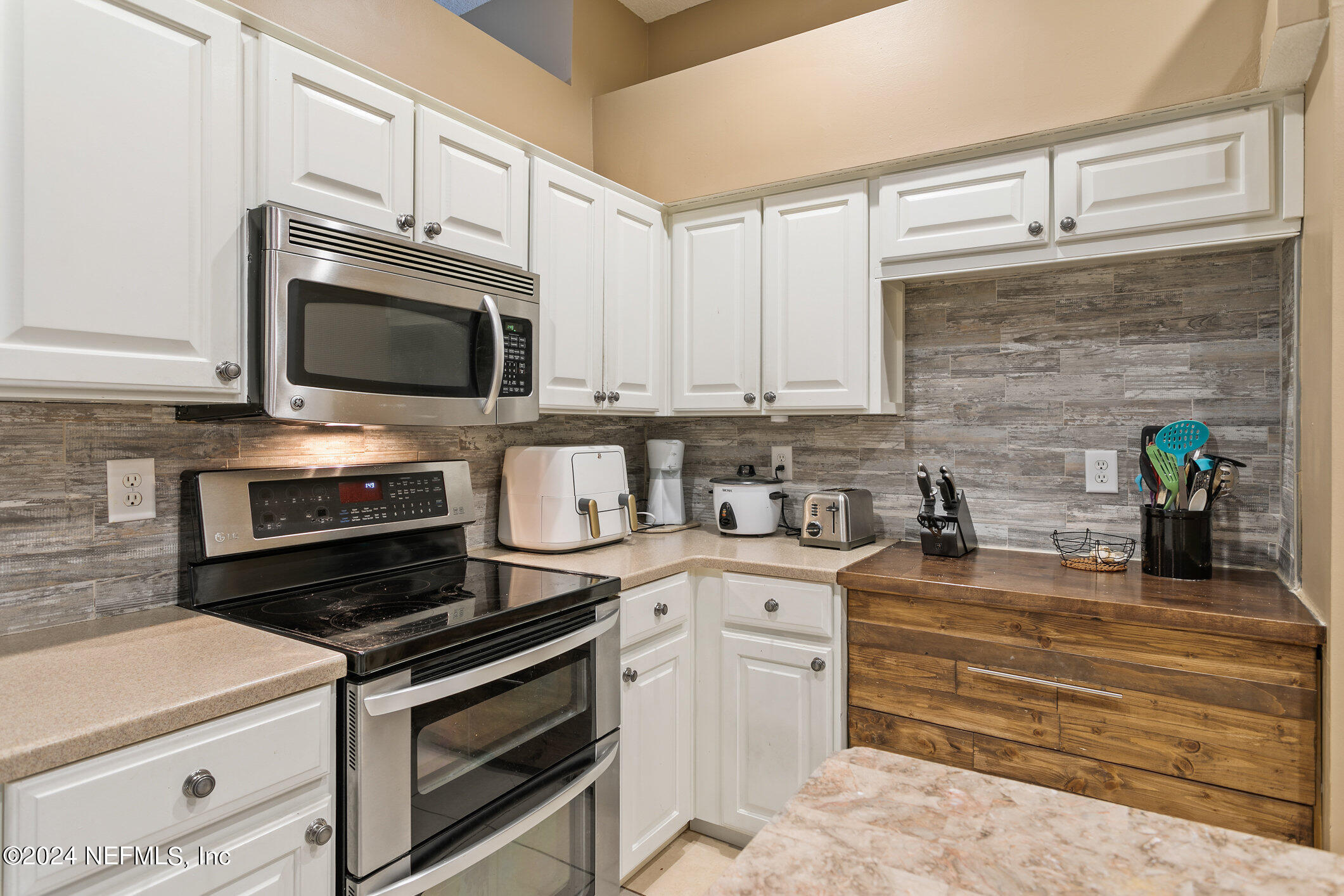 809 Mill Pond Court St. Johns, FL 32259 - Photo 7 of 50 a kitchen with granite countertop a stove microwave and cabinets