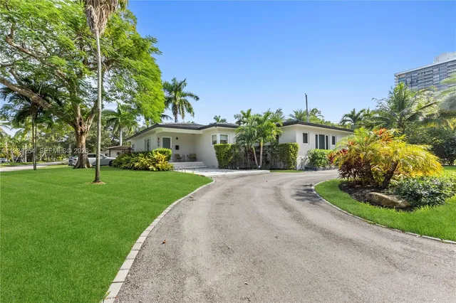 a living room with furniture a flat screen tv and a chandelier