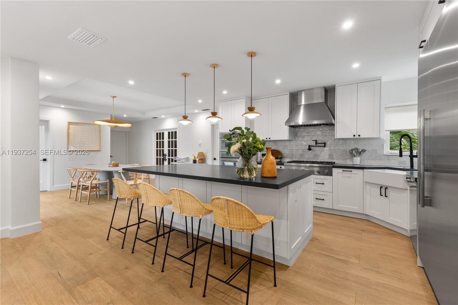 800 Northeast 72nd Street Miami, FL 33138 - Photo 11 of 48 a kitchen with stainless steel appliances kitchen island granite countertop a sink a stove a dining table and chairs
