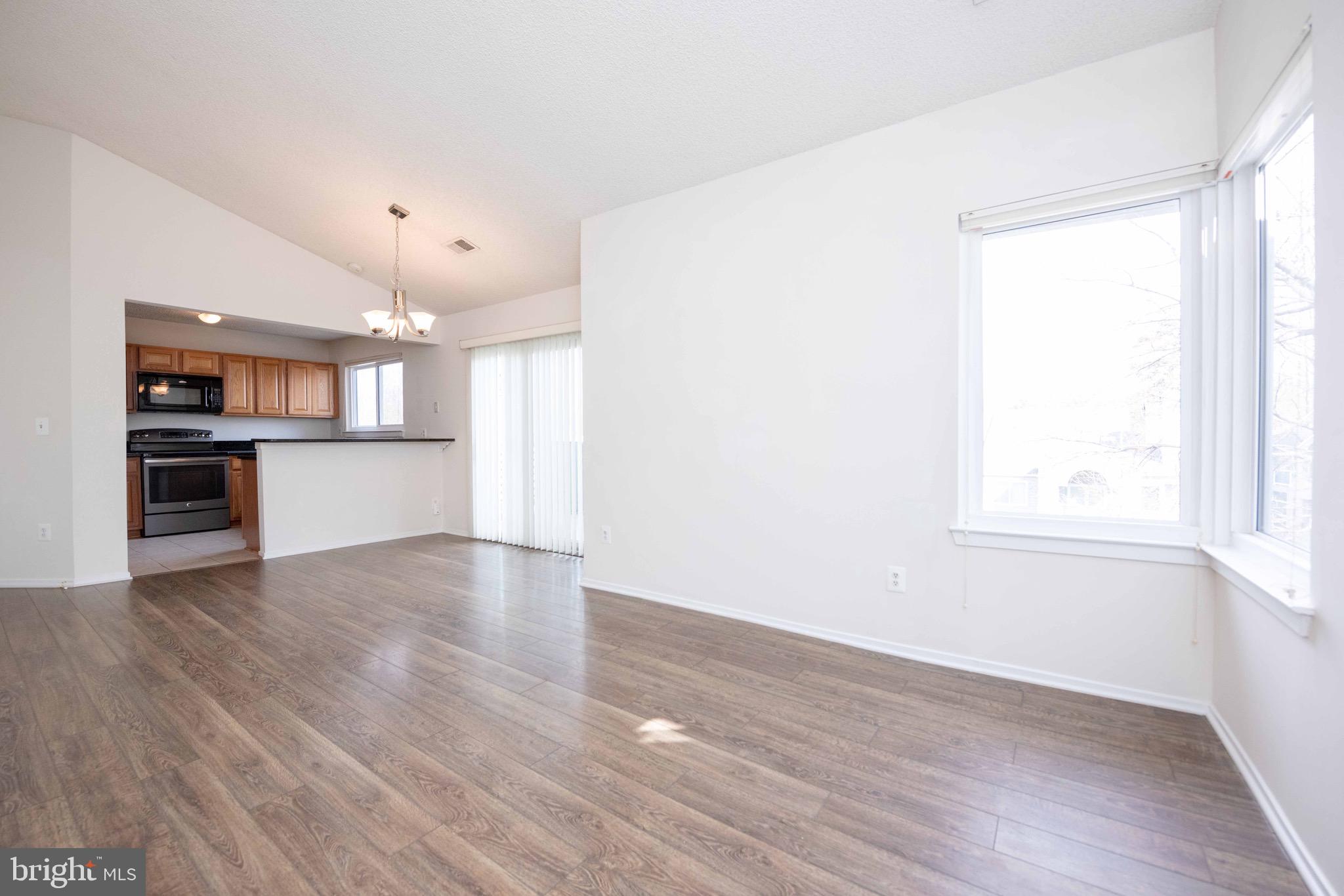 11708 Summerchase Circle, Unit 1708E Reston, VA 20194 - Photo 2 of 17 an empty room with wooden floor and windows